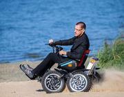 Rollstuhlfahrer fährt im Geländerollstuhl ZOOM am Strand