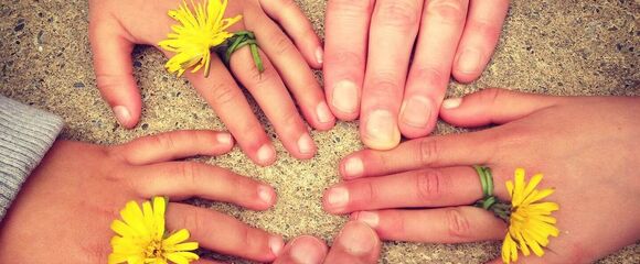 Hände im Kreis gelegt , mit Blumen