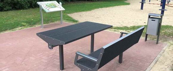 Unterfahrbare Pulttafel mit Informationen und Picknick-Sitzgruppe.