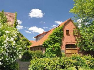 Die Naturschutzstation. Ein rotes Ziegelsteingebäude im Grünen.
