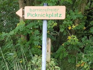 Ein Wegweiser mit der Aufschrift "barrierefreier Picknickplatz"
