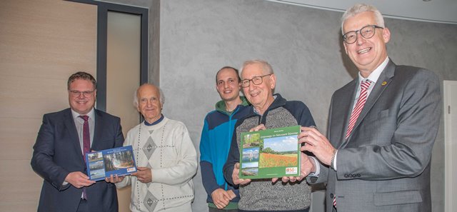Die Landräte von Vechta und Diepholz halten mit den Autoren und einem Naturpark-Mitarbeiter die neuen Bücher in die Kamera