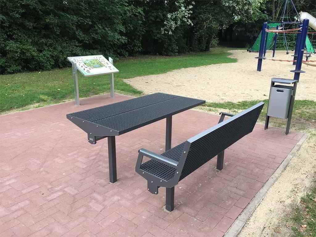 Unterfahrbare Pulttafel mit Informationen und Picknick-Sitzgruppe.