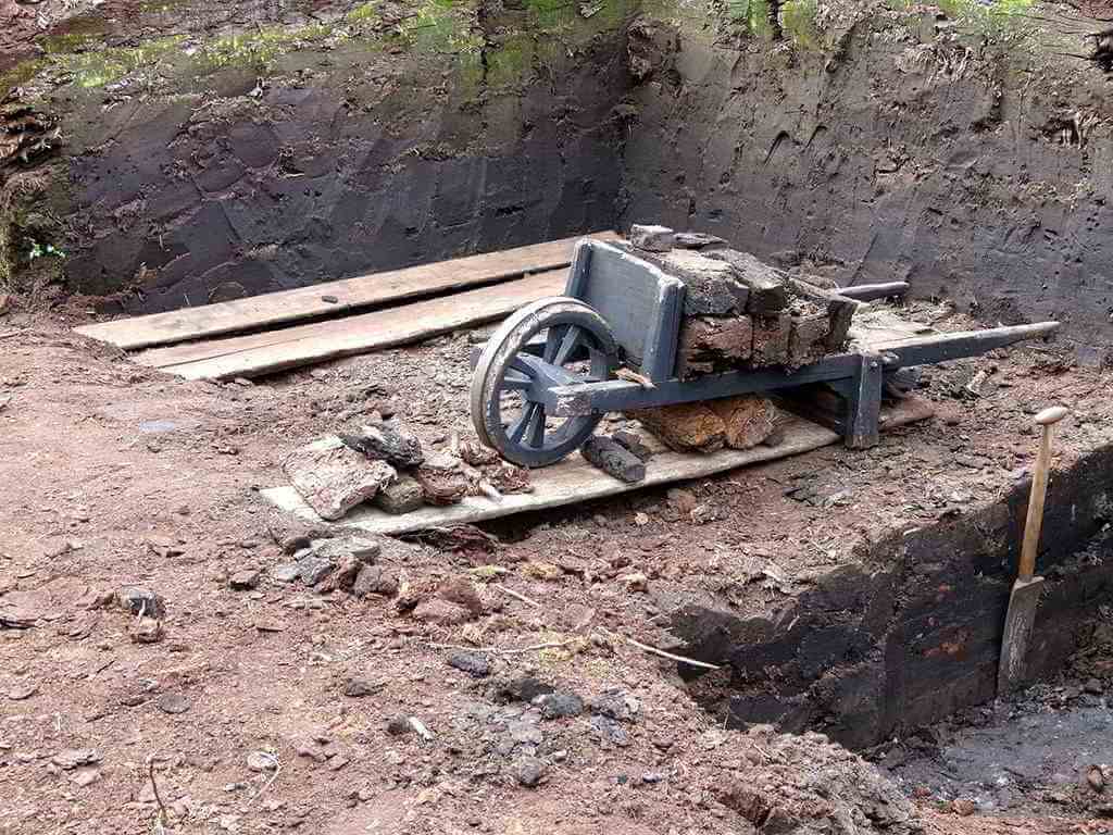 Eine alte Holzschubkarre, beladen mit Torf.
